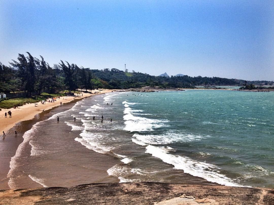 Enseada cercada por pedras e vegetação na região da Praia do Morro, em Guarapari.